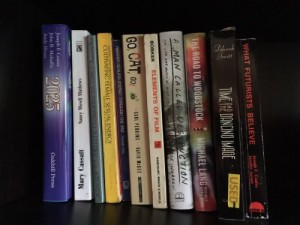 A row of books sitting on a black bookshelf.